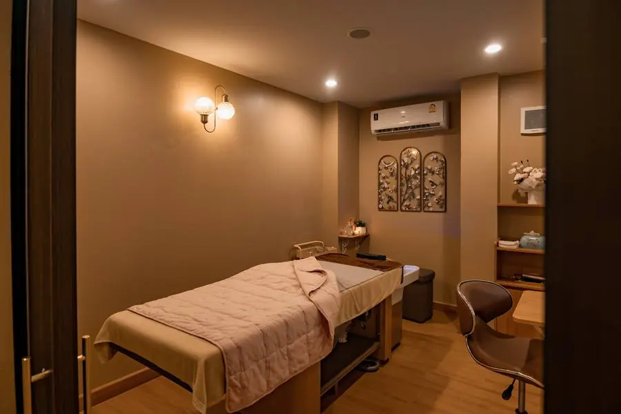 ห้องทรีตเมนต์ส่วนตัว เตียงนวดพร้อมโคมไฟและมุมแต่งตัว